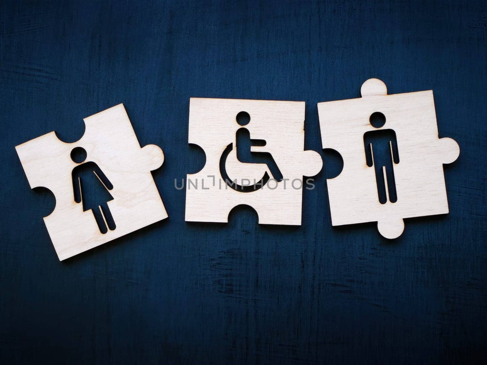 Puzzle pieces with female, male figures and disability person sign. Inclusion concept. by designer491