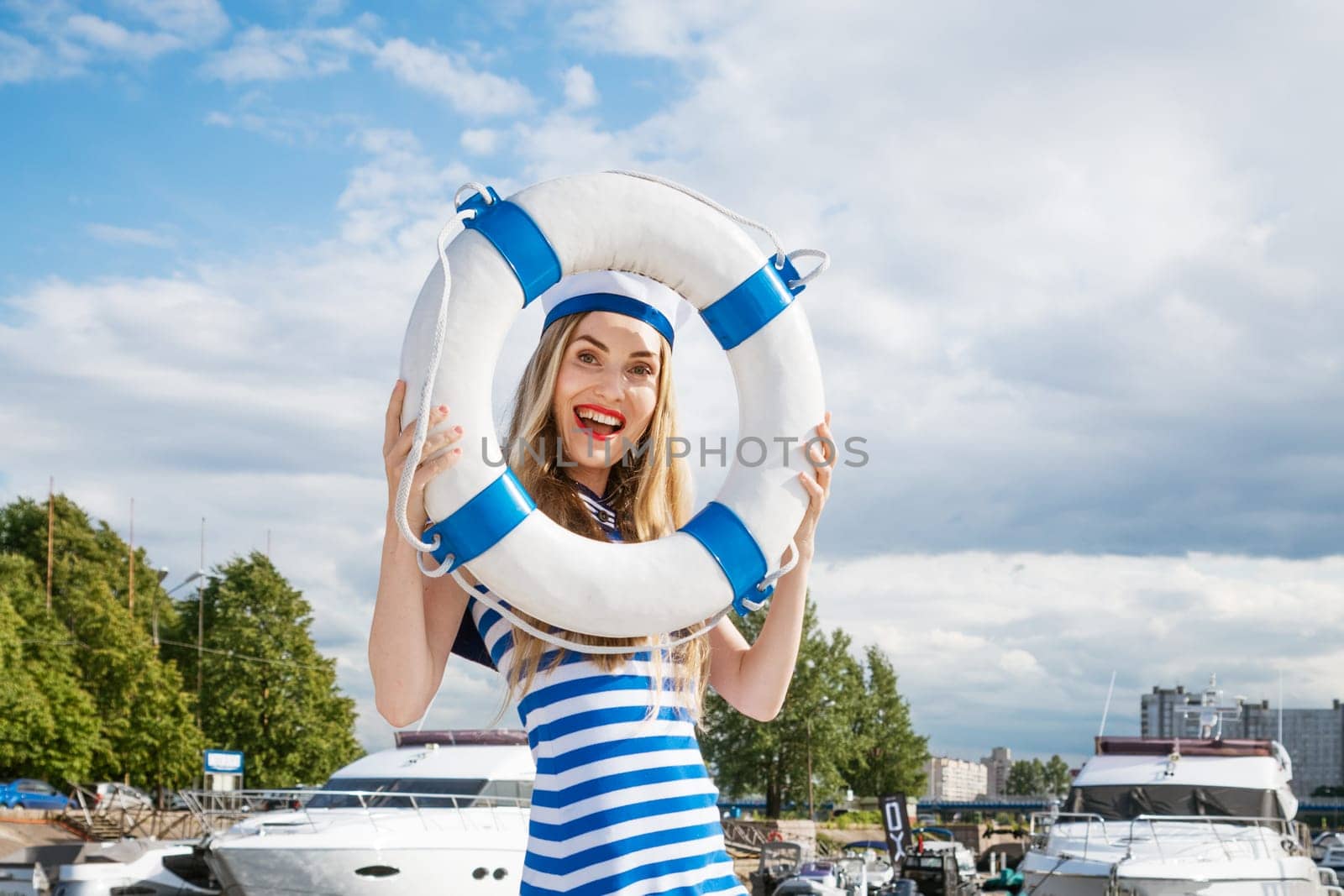 Young woman standing on yacht posing with lifebuoy by EkaterinaPereslavtseva