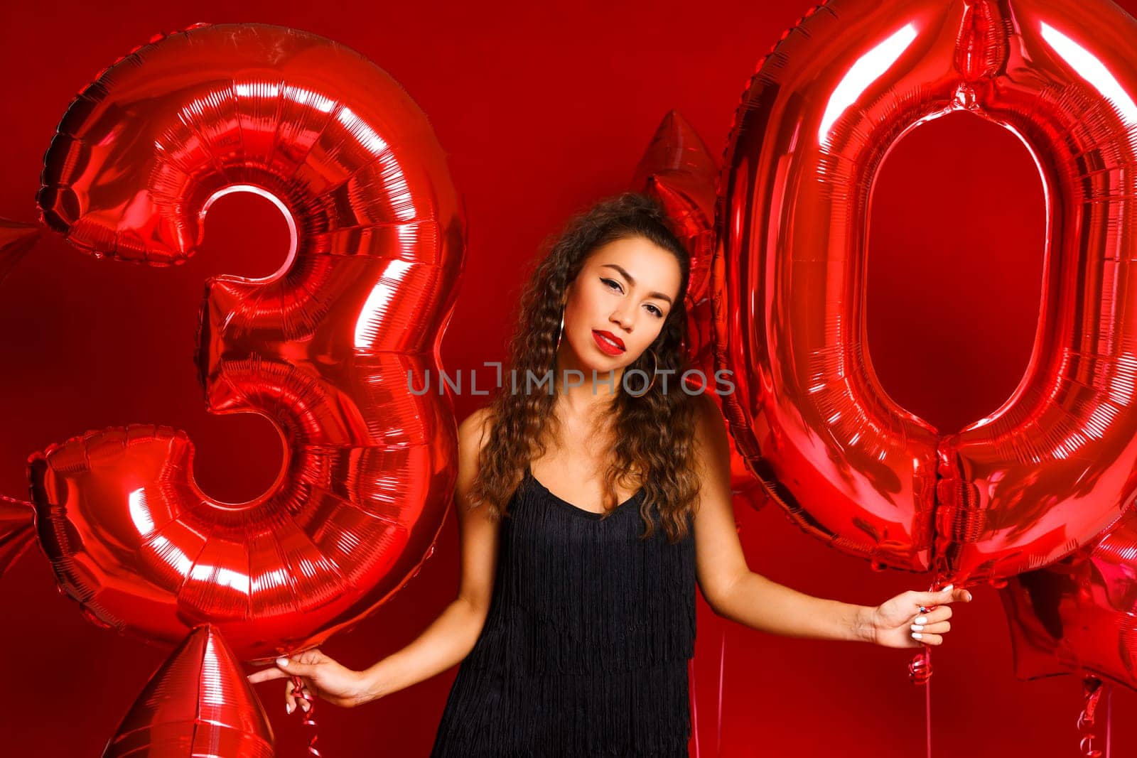 Portrait of happy 30 year old woman on red background by EkaterinaPereslavtseva