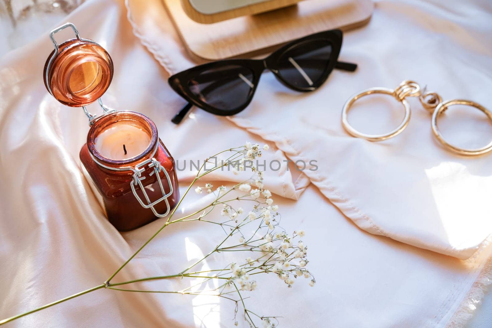 there is a decorative candle in a jar and glasses on the fabric by EkaterinaPereslavtseva