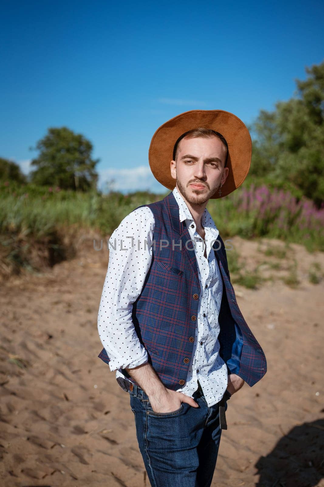 Young man in a hat on nature looks to the side by EkaterinaPereslavtseva