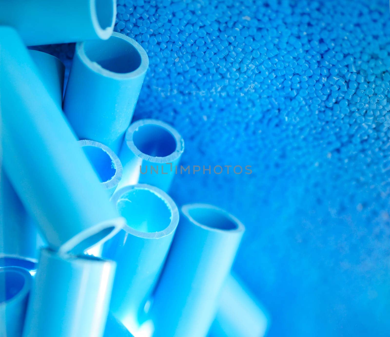 Blue pipe and plastic polymer pellets raw material for blue pvc pipe production. Industrial plastic resin. Chemical polymer granules. Thermoplastic. Plastic from petrochemical and compound extrusion. by Fahroni