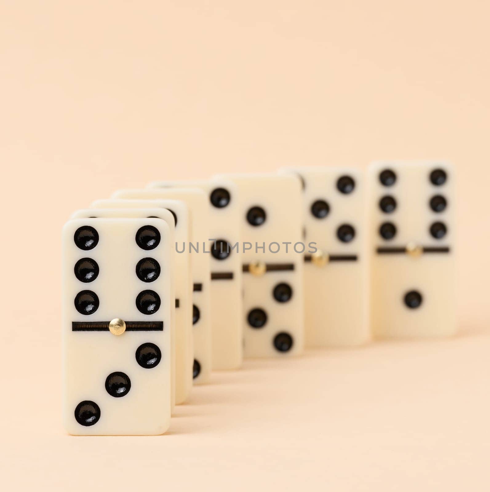 A stack of dominoes on a beige background, an intellectual game by ndanko