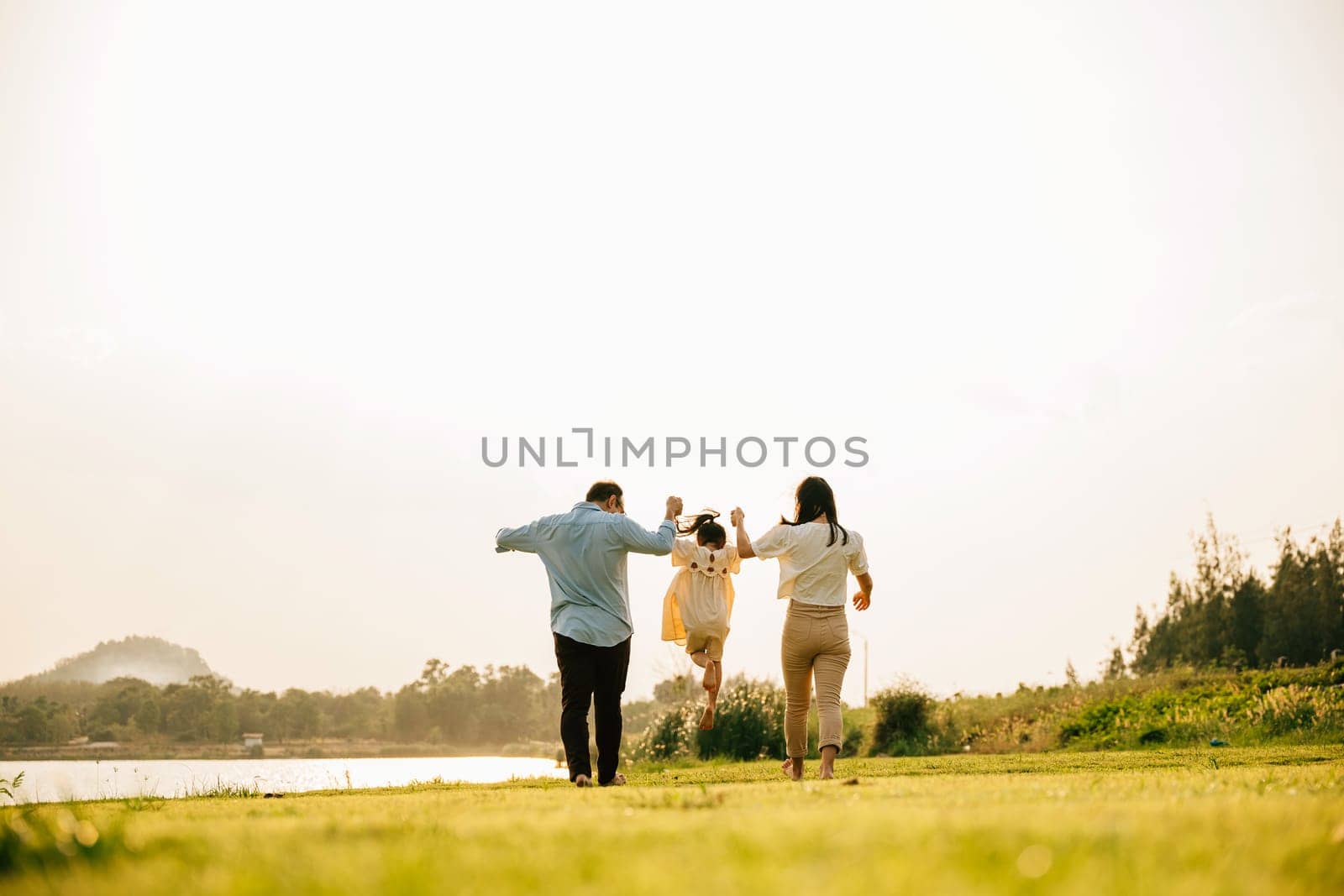 group of family running and having fun in a sunny park by Sorapop