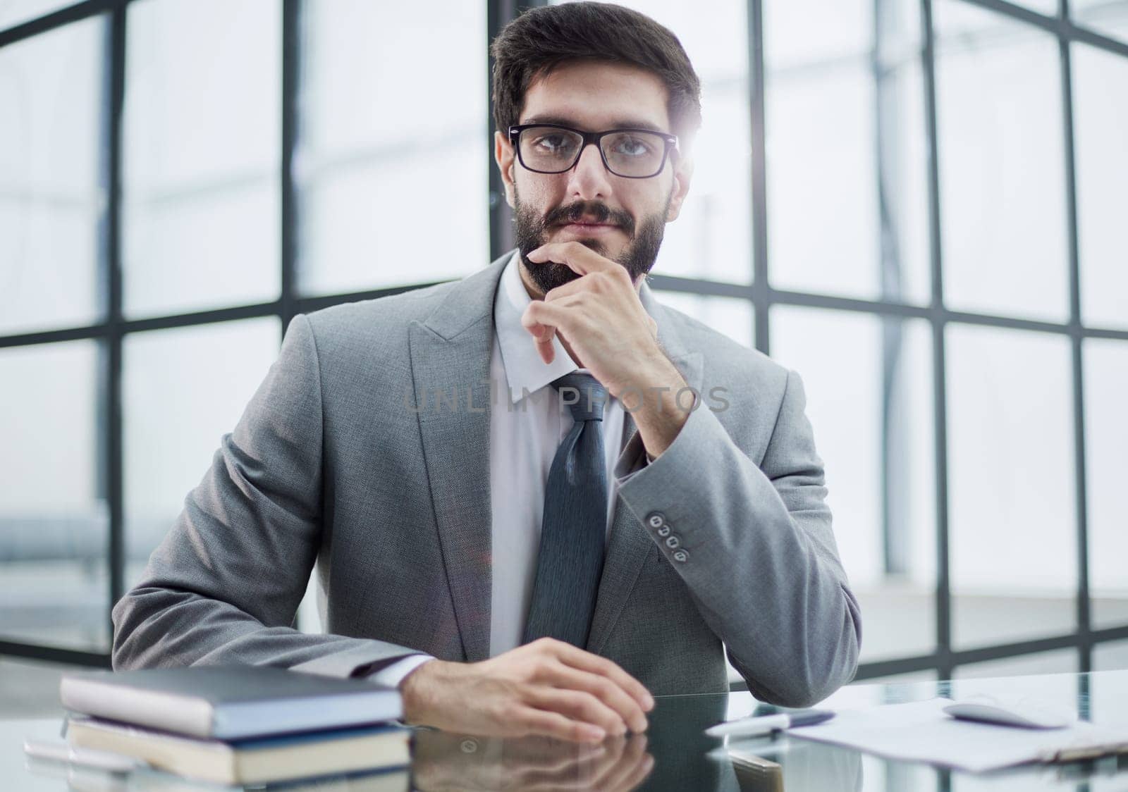Image of successful businessman rub his beard , having an interesting idea