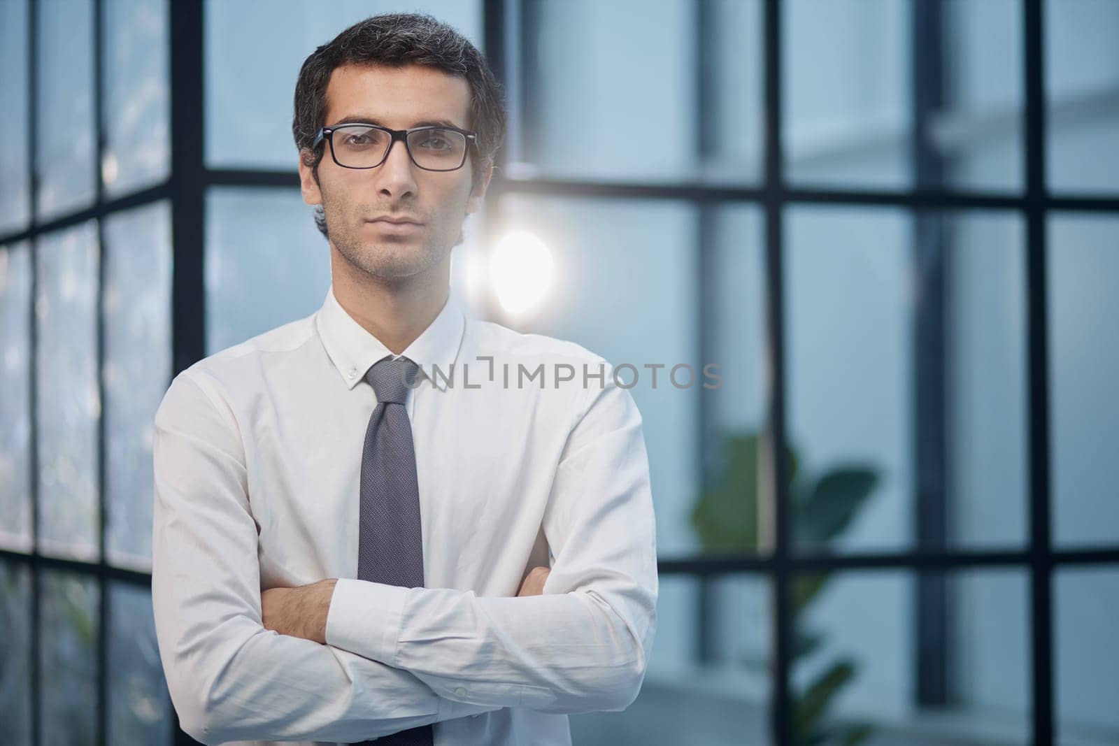 Dedicated to his business. Shot businessman standing with his arms crossed crossed in an office at work.