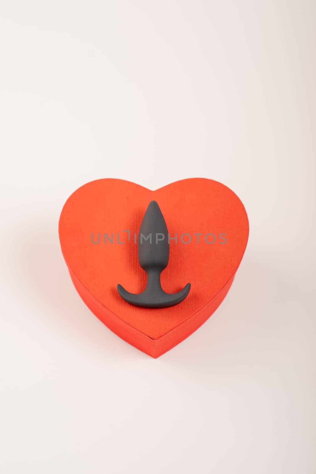 Heart-shaped box and butt plug on a white background. Love on February 14. by mrwed54