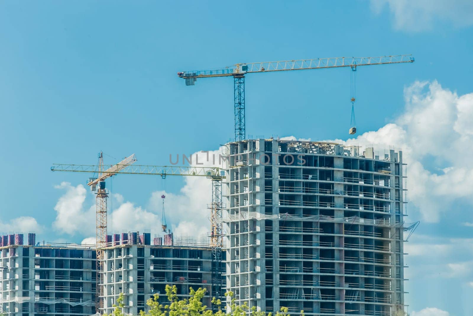 Tower crane, development of urban structures and construction of houses industry architecture on blue sky background.