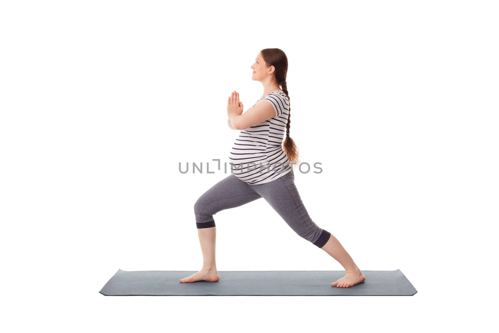 Pregnant woman doing yoga asana Virabhadrasana 1 isolated by dimol