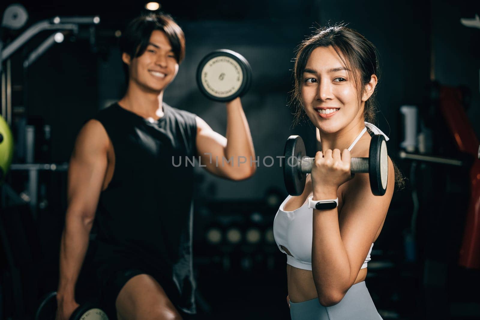 Portrait strong and athletic Asian man and woman, working out in a gym with barbells by Sorapop