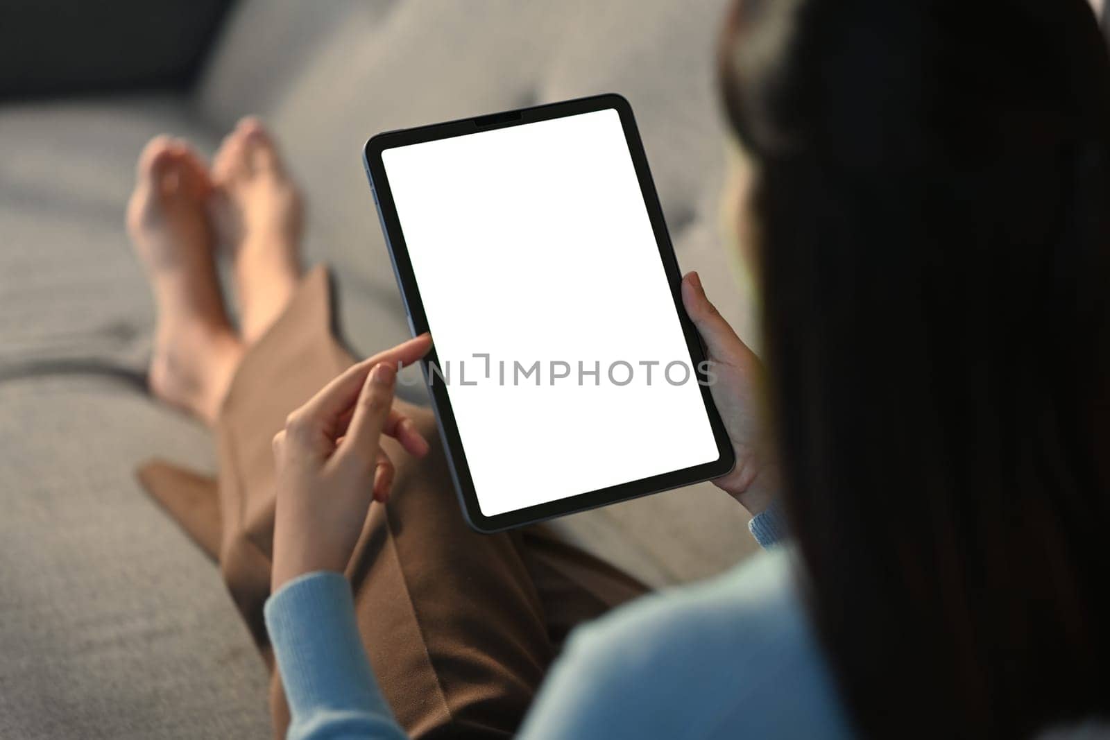 Closeup woman holding empty screen of digital tablet on sofa. High quality photo