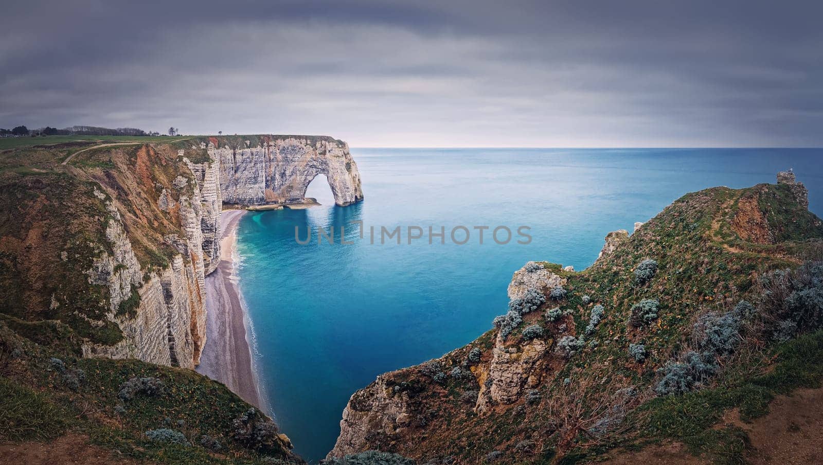 Idyllic panorama of Porte d'Aval natural arch at Etretat famous cliffs washed by Atlantic ocean, Normandy, France. Sightseeing coastline scenery, beautiful natural bay with sand beach by psychoshadow