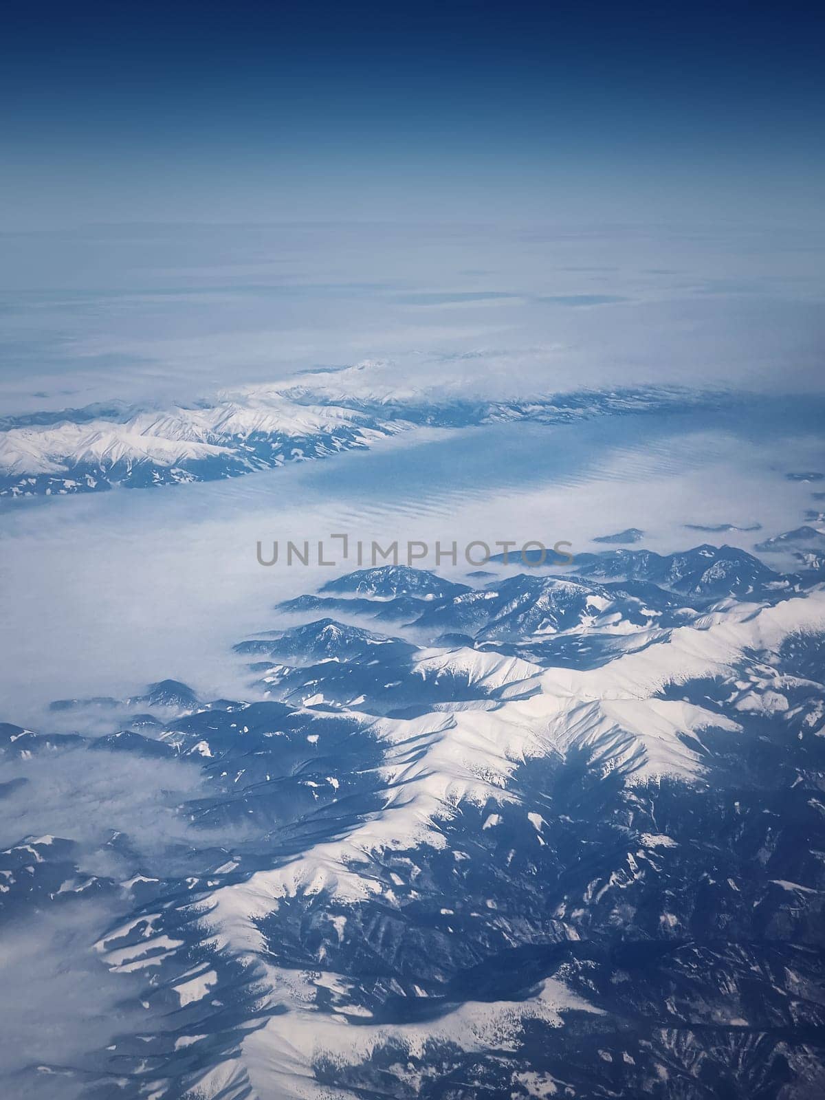 Mountainscape aerial view above the Carpathian mountains snowy peaks, vertical background by psychoshadow