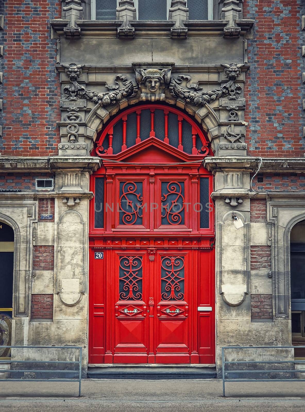 Vintage red door and ornate facade details of an old historical building in Rouen, France. Rustic outdoors architecture elements, big wooden gate as main entrance
