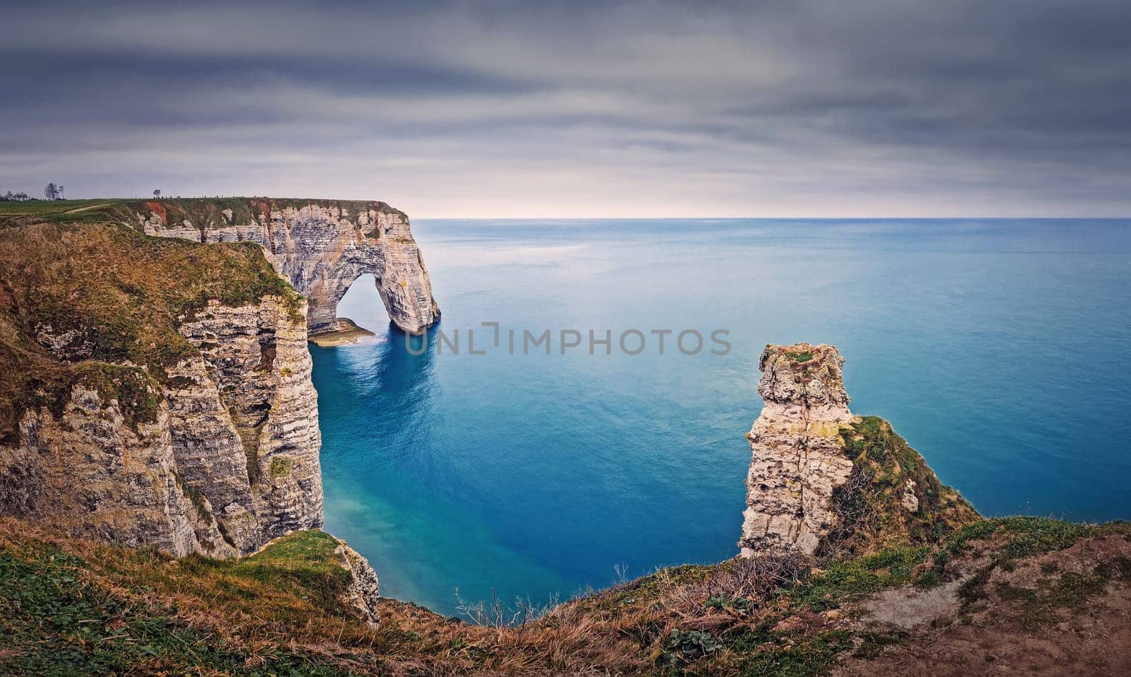 Beautiful view to the Porte d'Aval natural arch at Etretat famous cliffs in Normandy, France