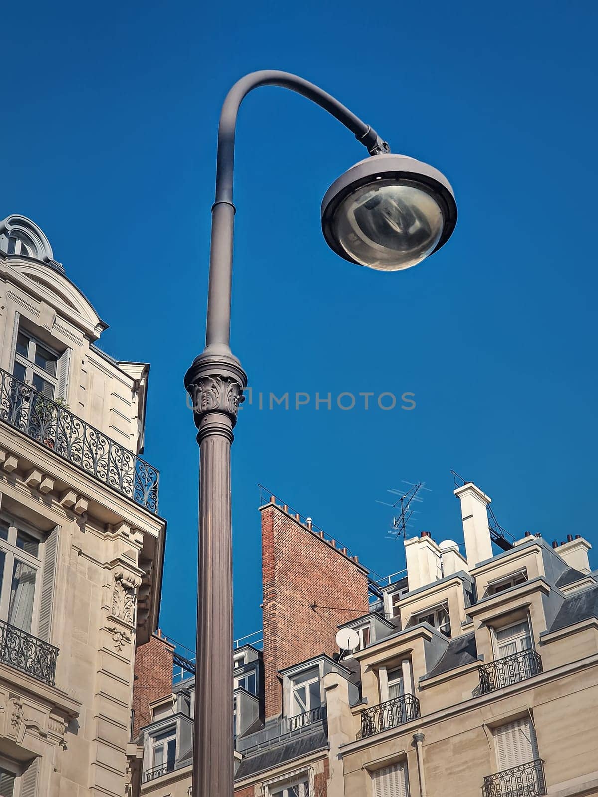 Retro style street lamp in an old Paris district with view to the blue sky background by psychoshadow