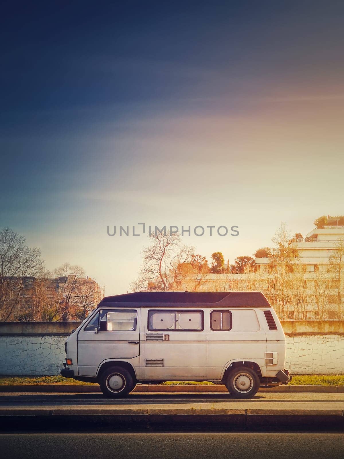 Old van parked on the edge of the street in the sunset sky background, Asnieres sur Seine, Paris suburb, France by psychoshadow