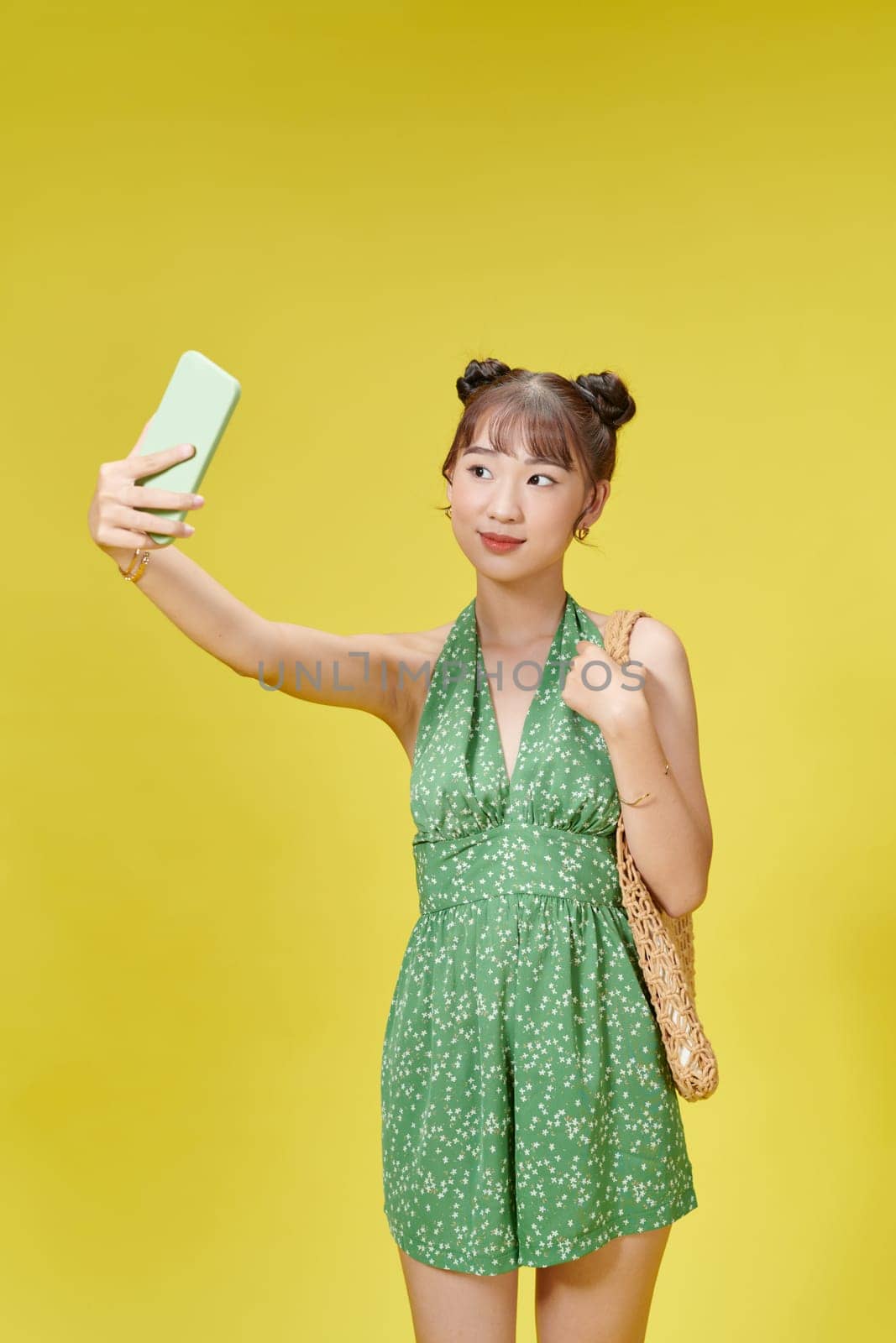 Portrait of young cheerful woman in summer wear makes selfie on smartphone