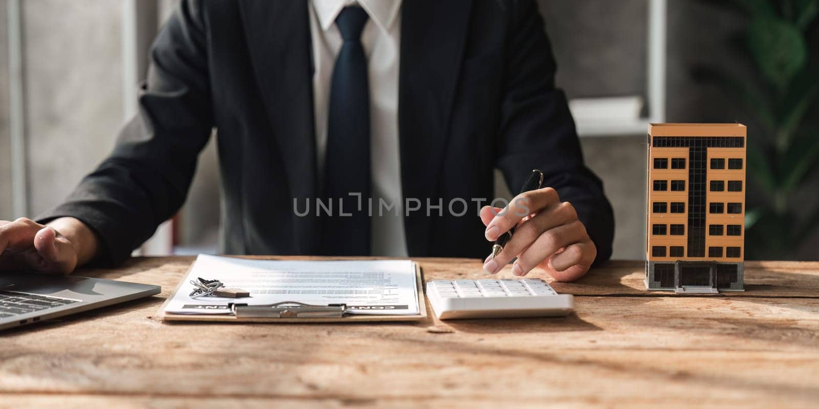 Bank loan workers are using calculators to calculate home loan interest rates for customers to assess their investment capabilities using key document.