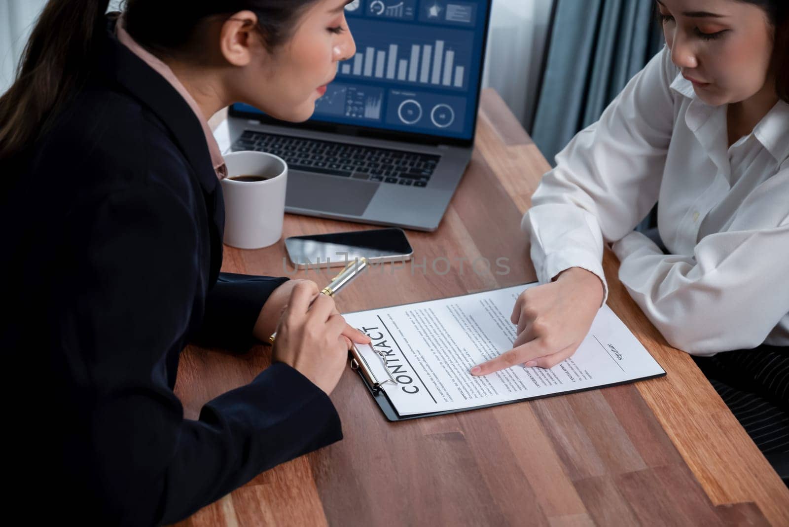 Business deal meeting, young businesswomen carefully reviewing terms and condition of contract agreement papers in office. Corporate lawyer give consultation on contract deal. Enthusiastic