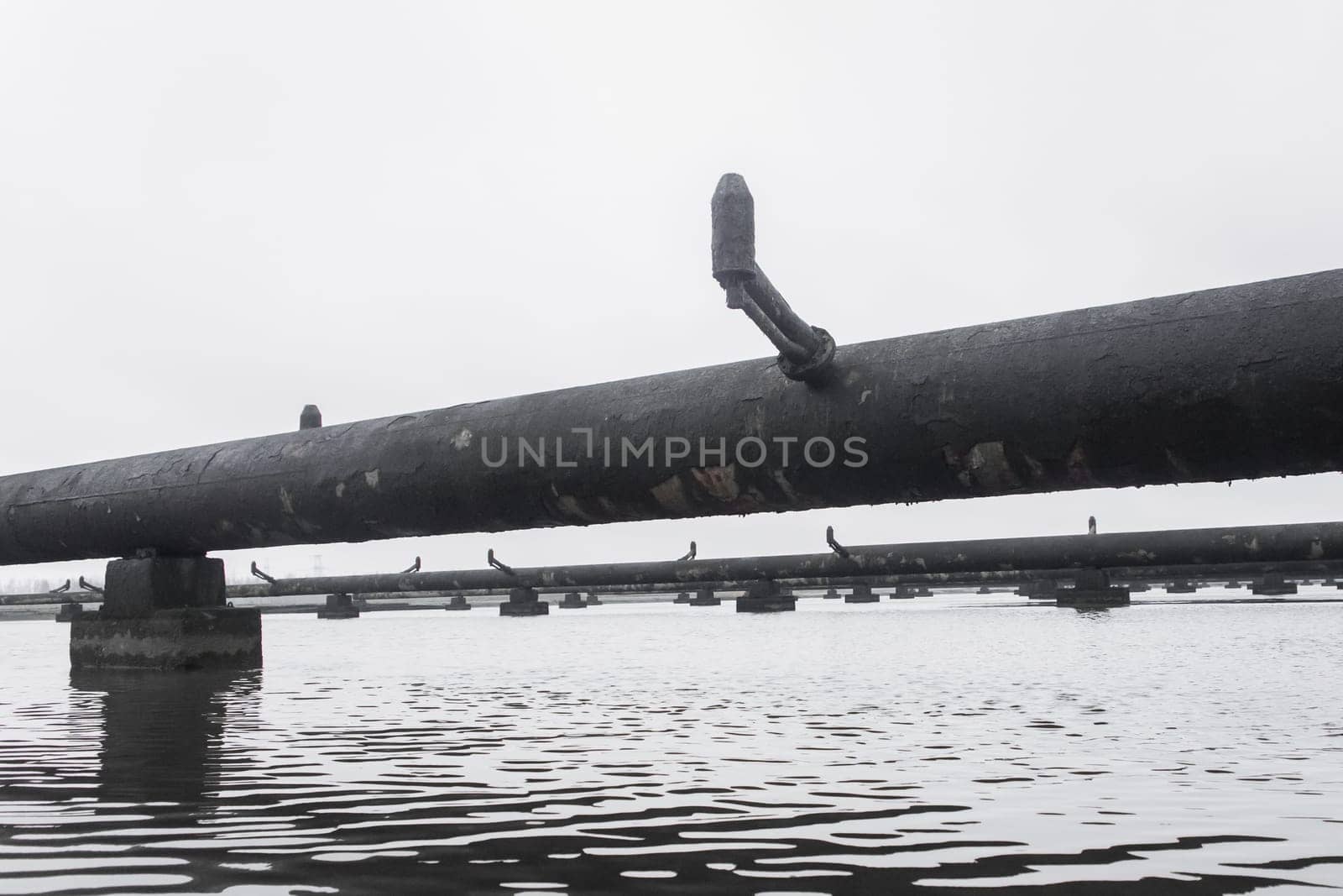 Old steel rusty abandoned pipes of the water cooling pipeline system of the combined heat and power industrial plant.