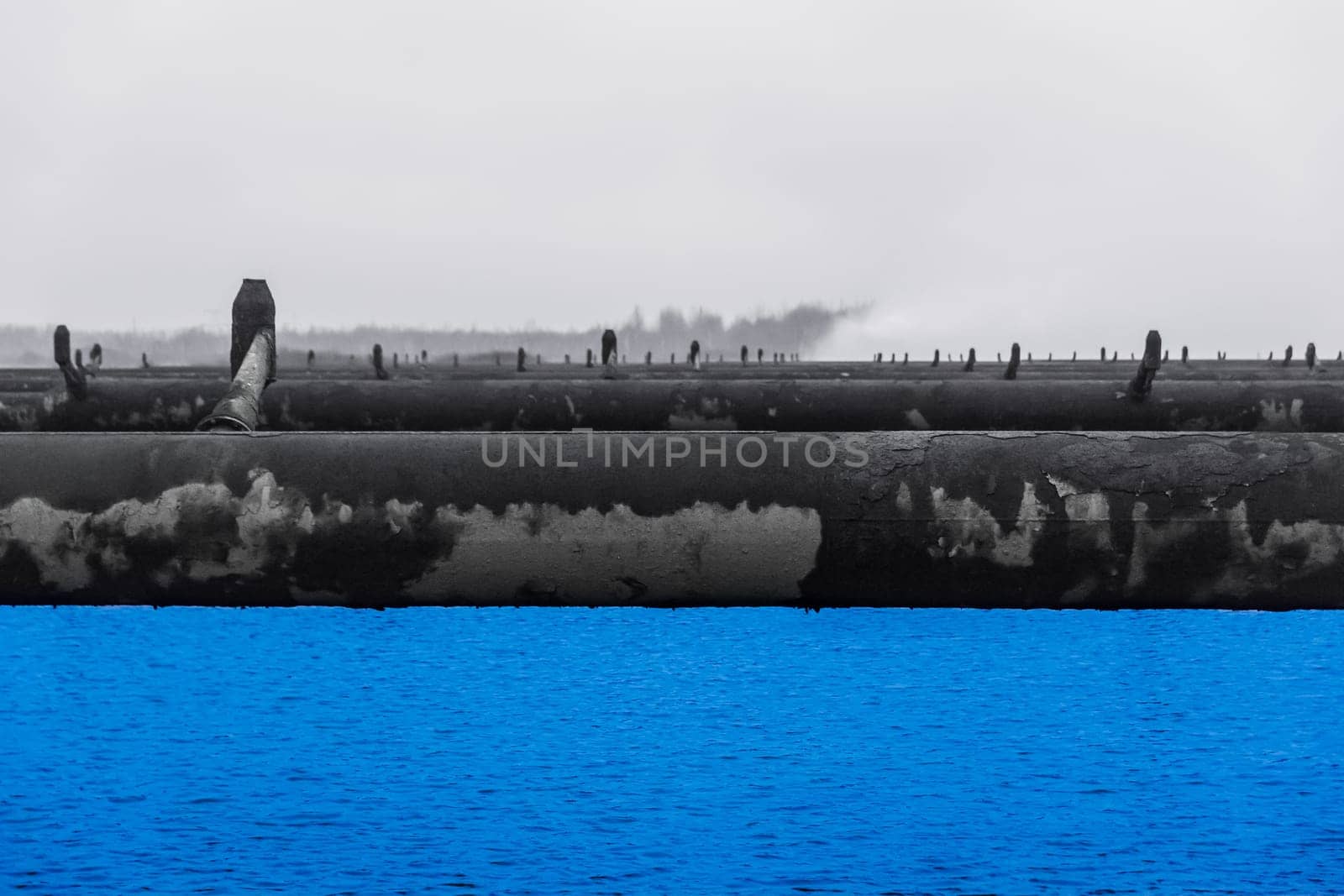 Old steel rusty abandoned pipes of the water cooling pipeline system of the combined heat and power industrial plant.