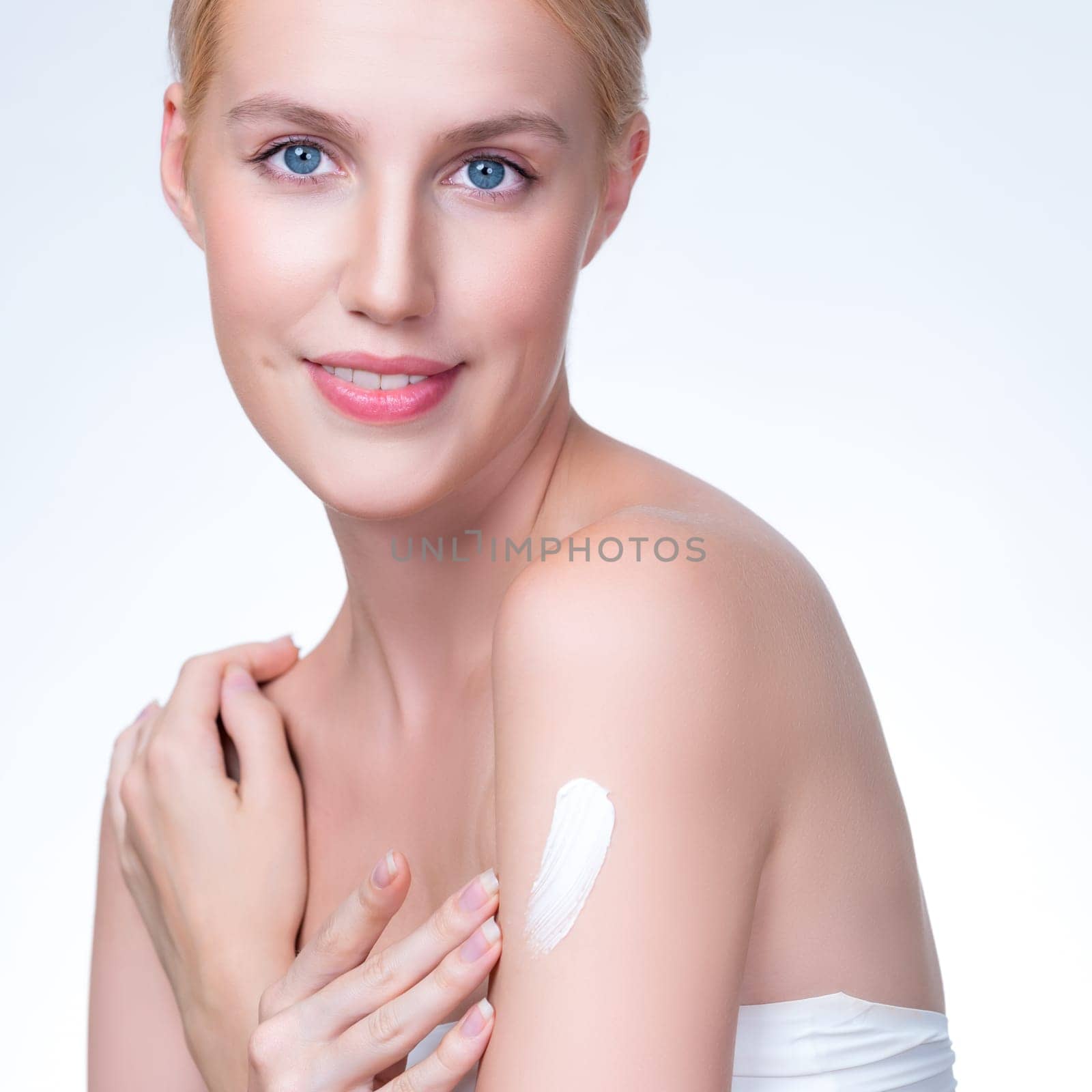 Closeup personable beautiful woman putting skincare cream on isolated background by biancoblue