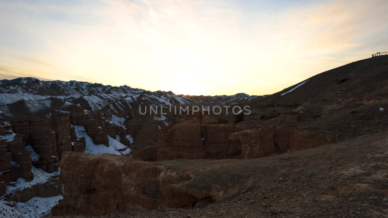 Charyn Grand Canyon with orange rock walls. Aerial view from the drone of the steep canyon walls, cracks and tunnels. There is snow in places. Beautiful sunset and sunrise. Brother of the Grand Canyon