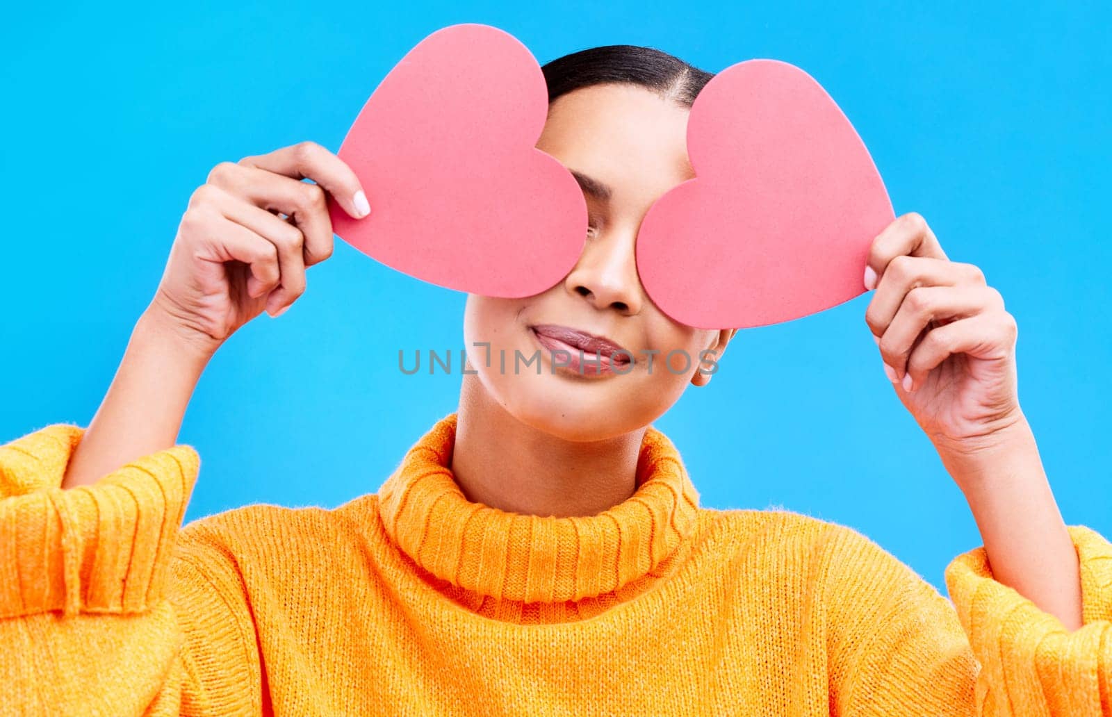 Heart eyes, cover and woman smile with happiness and excited for love, valentines day or studio emoji. Happy, loving or person on isolated blue background, creative romance paper and show care symbol.