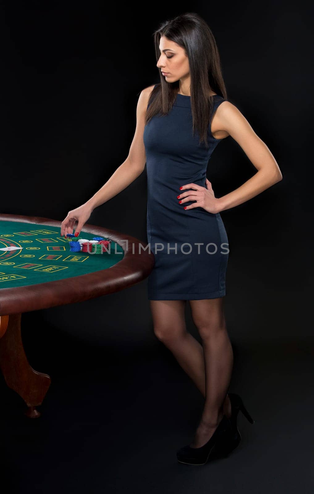 sexy woman with poker cards and chips. Female player in a beautiful black dress