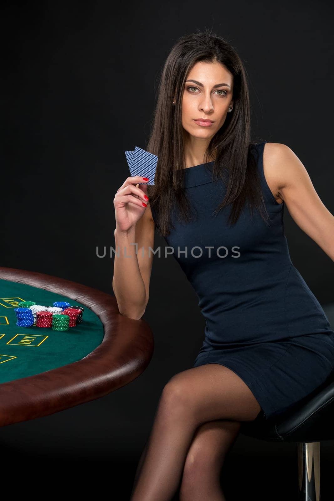 sexy woman with poker cards and chips. Female player in a beautiful black dress