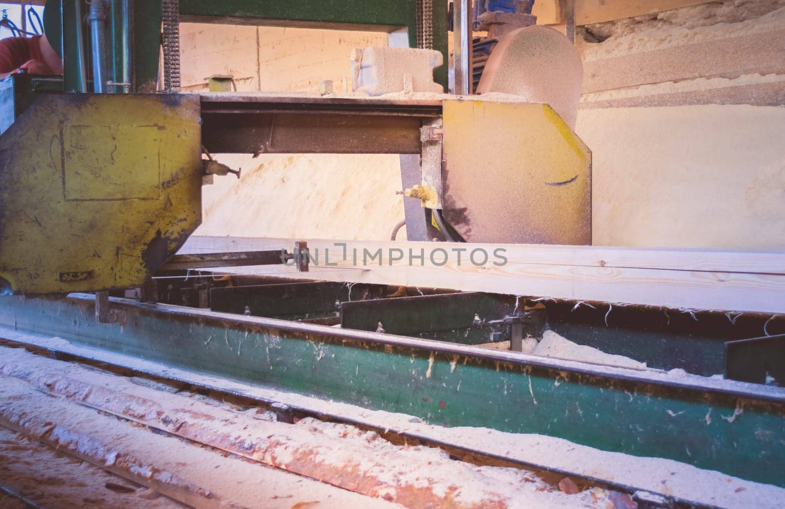 Sawmill. Process of machining logs in equipment sawmill machine saw saws the tree trunk on the plank boards. Wood sawdust work sawing timber wood wooden woodworking