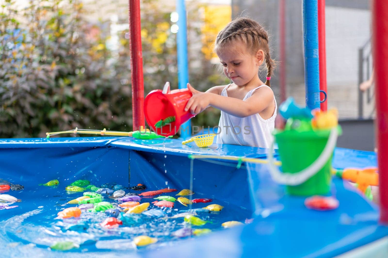 Child Fisher Catching Plastic Toy Fish On Pool Amusement Park Summer Day Little Girl Have Fun On Fishing Carnival Festival Entertainment For Children