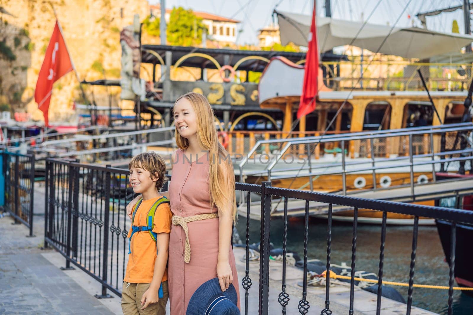 Mom and son tourists in Old town Kaleici in Antalya. Turkiye. Panoramic view of Antalya Old Town port, Taurus mountains and Mediterrranean Sea, Turkey. Traveling with kids concept by galitskaya