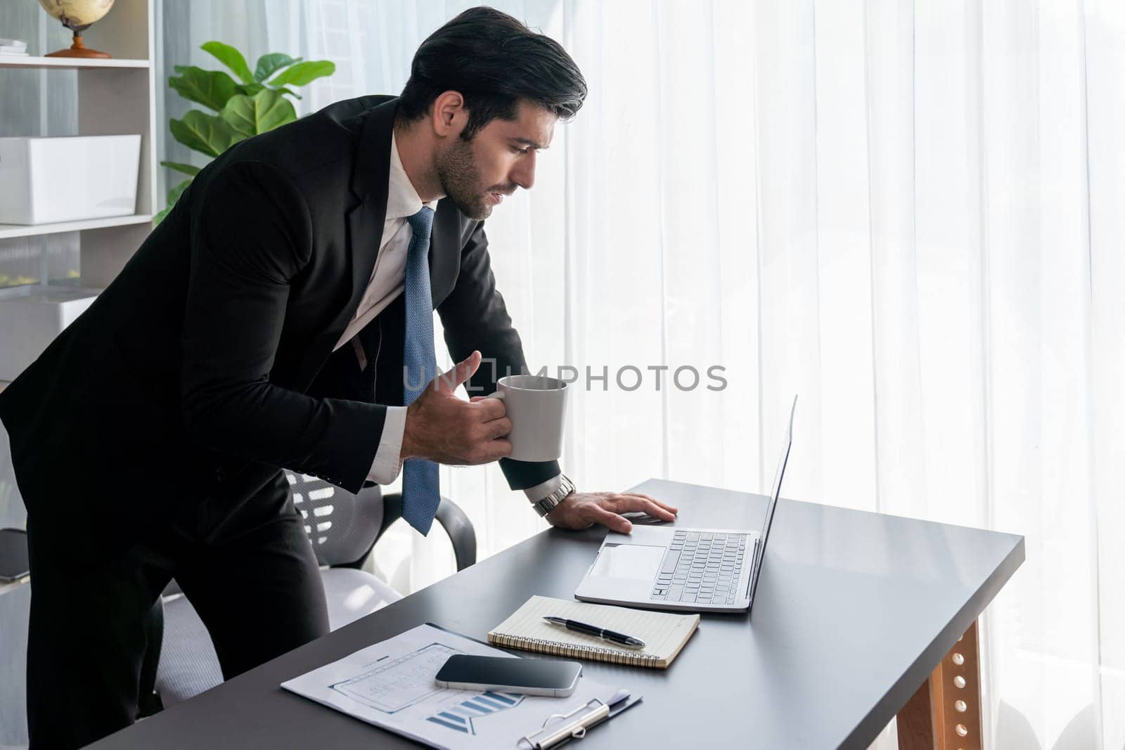 Modern professional businessman at modern office desk with coffee. fervent by biancoblue