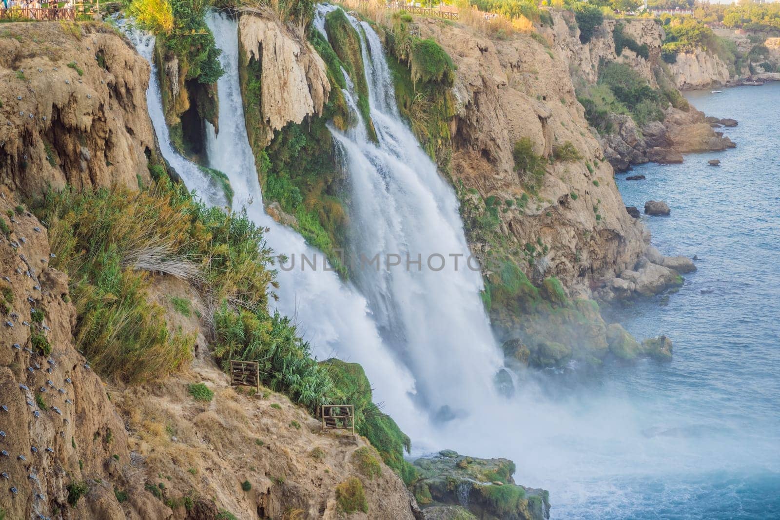 Lower Duden Falls drop off a rocky cliff falling from about 40 m into the Mediterranean Sea in amazing water clouds. Tourism and travel destination photo in Antalya, Turkey. Turkiye. by galitskaya