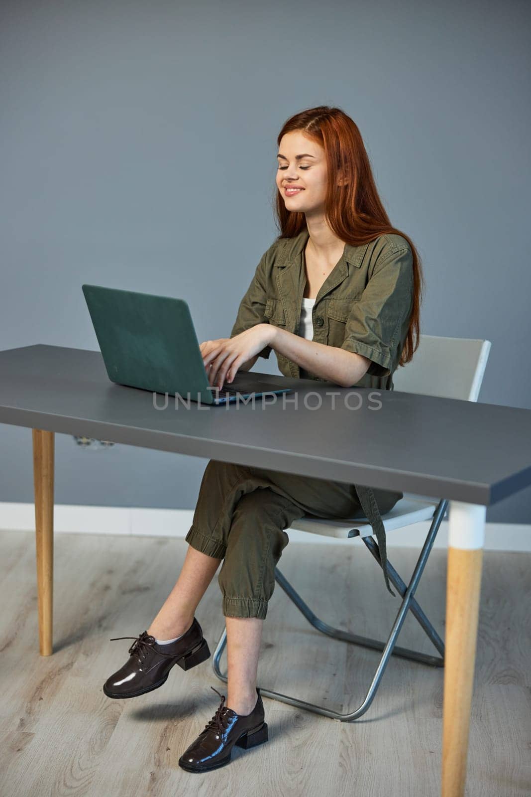 happy, joyful woman sitting at work at a laptop in the office. Work, technology. High quality photo