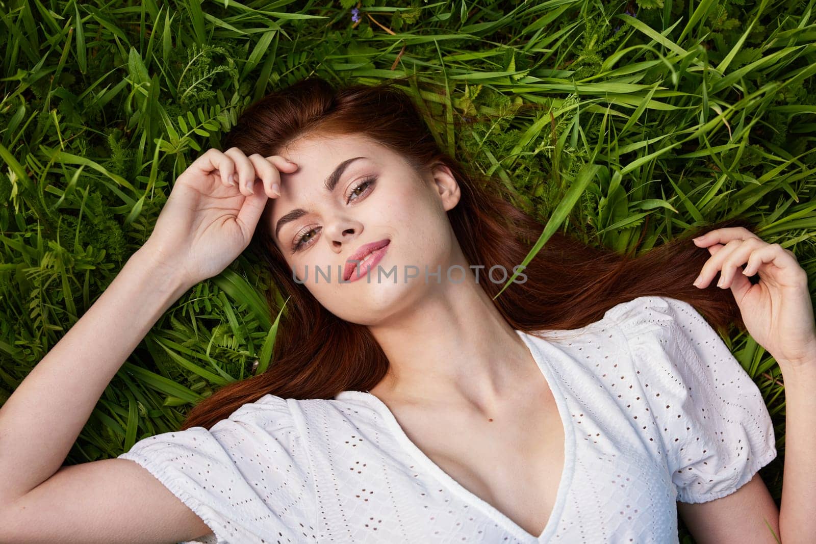 beautiful smiling woman dreaming while lying in the grass. High quality photo