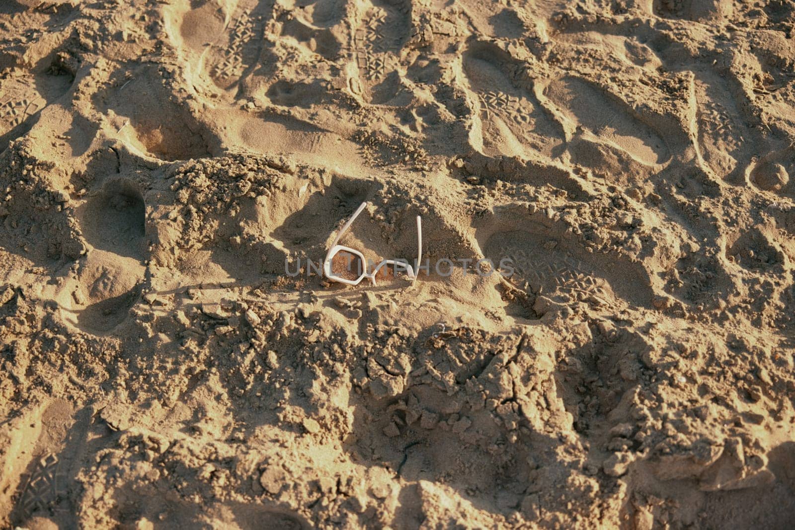 light, massive glasses lying in the sand near the sea. High quality photo