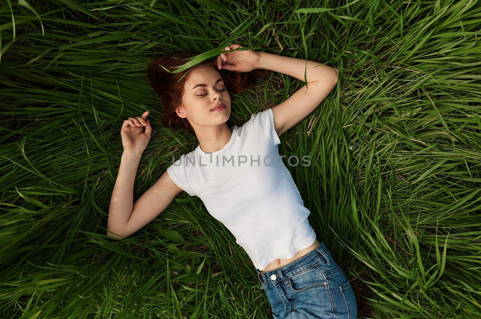 happy woman lies in green grass field. High quality photo