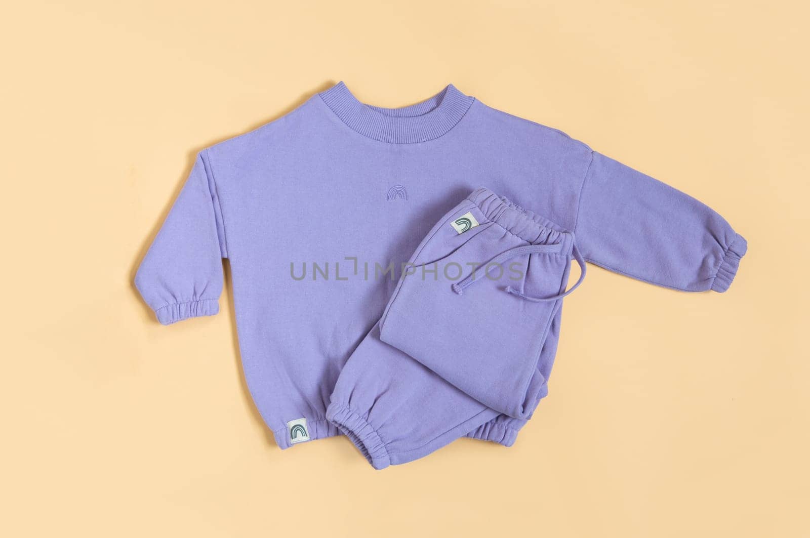 Stylish lilac children's spring, autumn sport costume. Soft touch, warm joggers and sweatshirt. Fashion kids outfit for spring, autumn and winter. Flat lay, top view