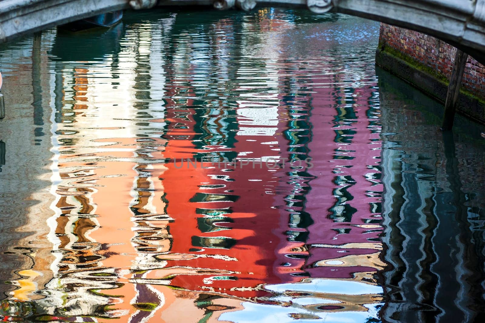 The colors of the buildings reflected on the water of one of the Venetian canals