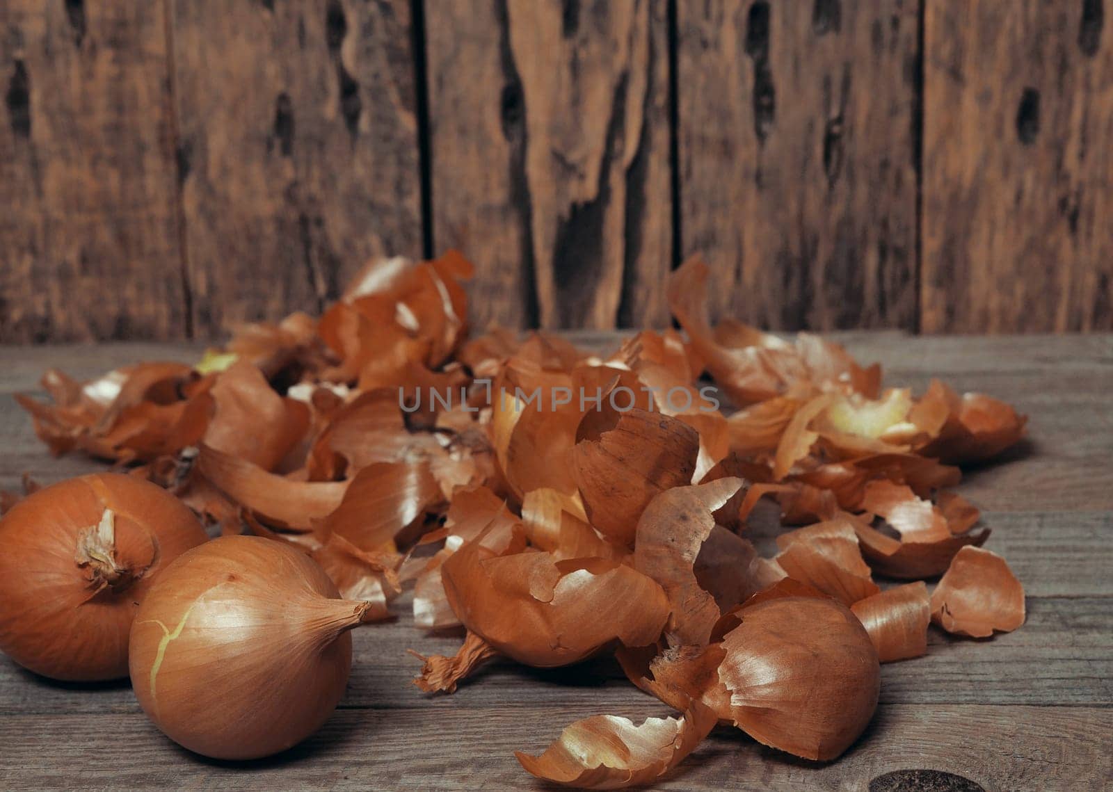 Food background with onion and husk on wooden natural background.The concept of onion health benefits for people.