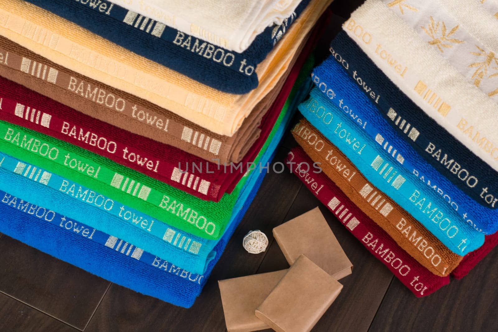 A closeup shot of heaps of folded colorful bamboo towels in a bathroom by A_Karim