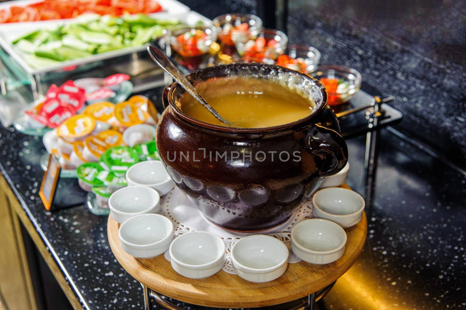 A bowl of soup puree on a buffet table with small bowls around