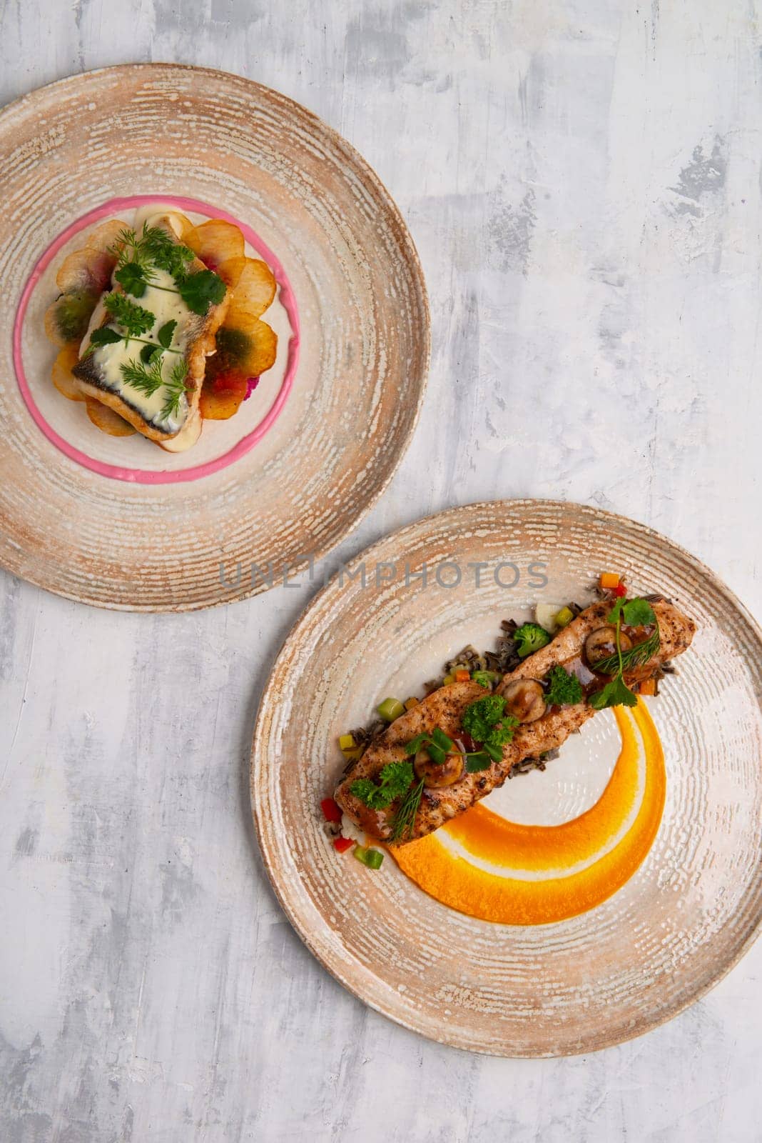 A top view of two beautiful and tasty food on plates isolated on a grey background by A_Karim