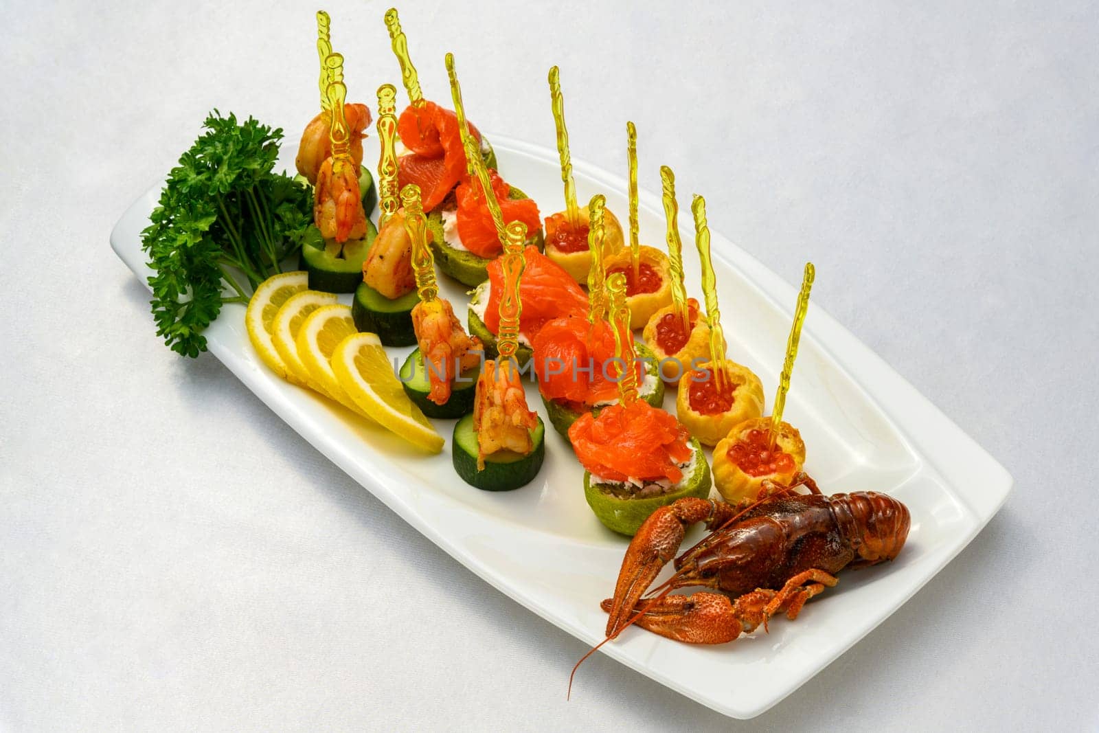 A cooked cancer with appetizers on skewers on the plate