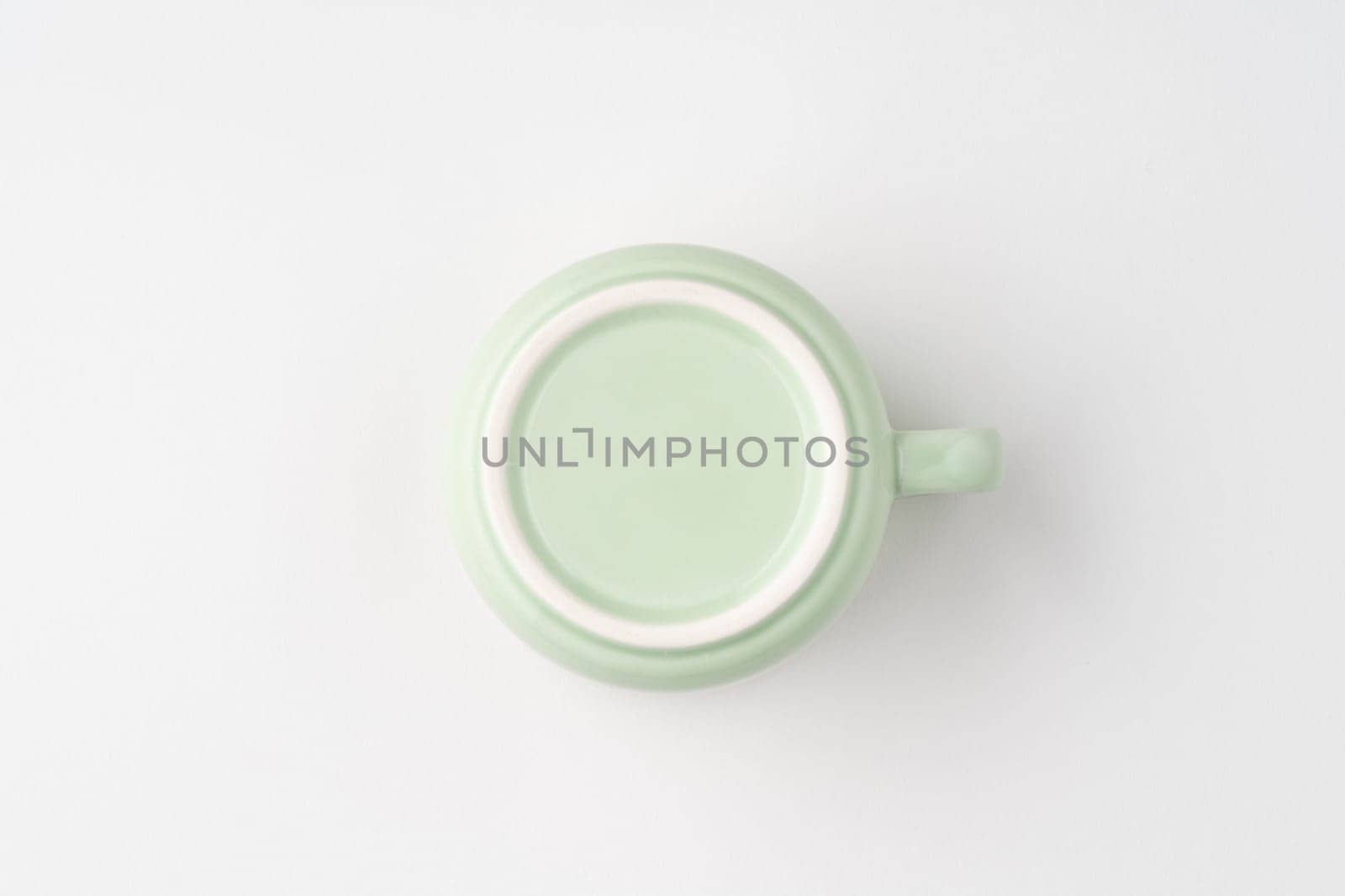 A shot of the underside of a pastel green tea cup. Top view by A_Karim