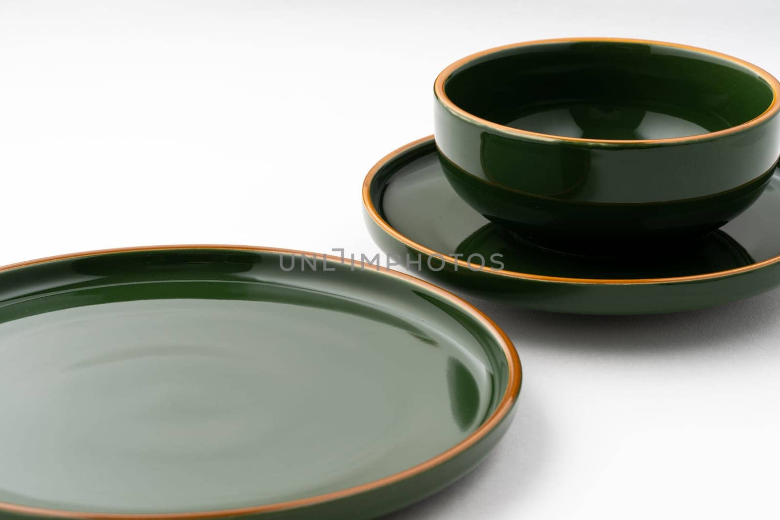 A set of dark green ceramic tableware with orange outlines on a white background by A_Karim