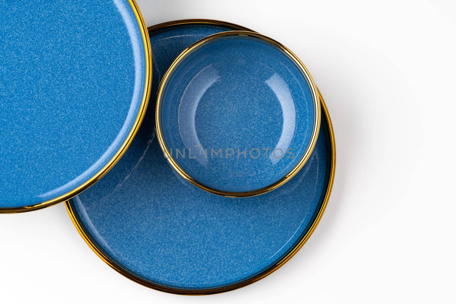 A set of blue ceramic plates on a white background. Top view